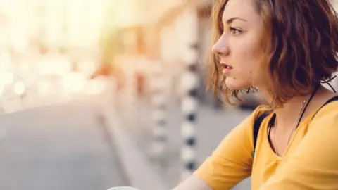 Getty Images Young women looking across a street