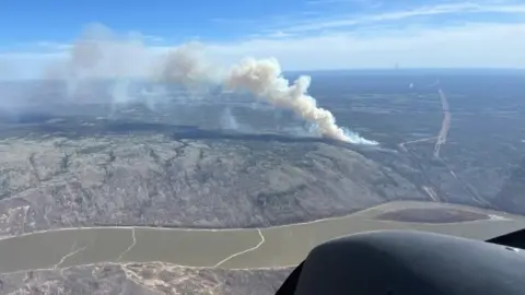 Smoke billows from burning wildfire