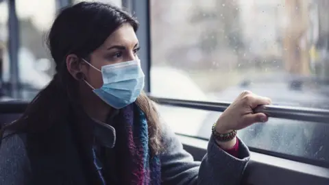 Getty Images Woman wearing a surgical mask