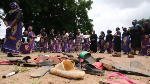 AFP Parents of kidnapped students from Bethel Baptist High School, in Nigeria's Kaduna state, stand by shoes left behind after the attack - July 2021