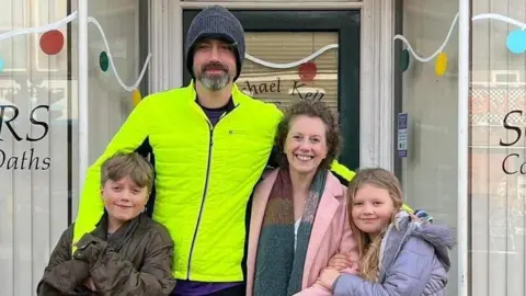 Family handout Sam left, Michael in the middle wearing a high vis jacket, Kelly and Isla on the right