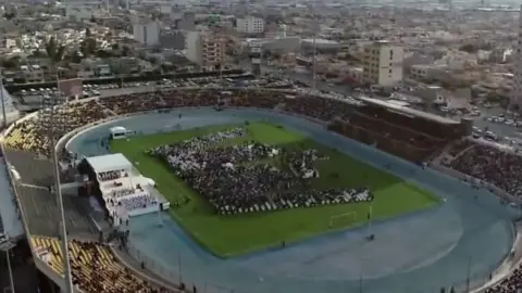 Picture showing people in stadium for Pope mass