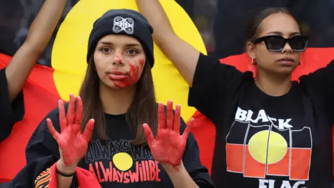 Getty Images Protesters with red paint on their hands at a rally against black deaths in custody