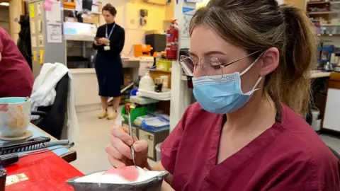 Nurse painting prosthetic eye