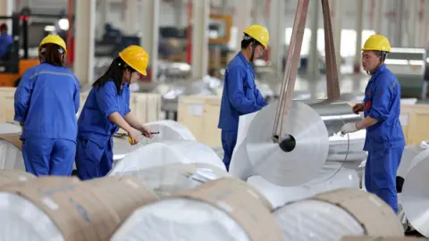 Getty Images Chinese workers packaging aluminium tapes at an aluminium production plant in Huaibei, east China's Anhui province