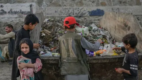 Getty Images Children looking in rubbish bins near Kabul airport - September 2021