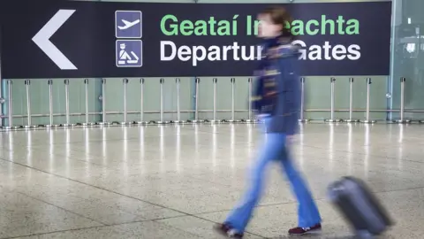 Getty Images A traveller walks toward the departure gate at Dublin Airport