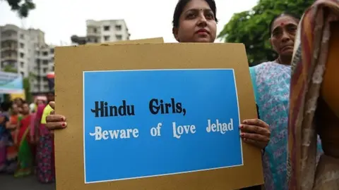 Getty Images An Indian Hindu holds a placard as she takes part in a rally against 'Love Jihad', in Ahmedabad on July 22, 2018.