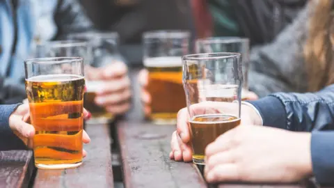 Getty Images Hands holding beer glasses