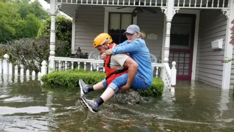 Reuters A Texas National Guard soldier carries a woman on his bank as they conduct rescue operations in flooded areas around Houston, Texas, U.S., August 27, 201