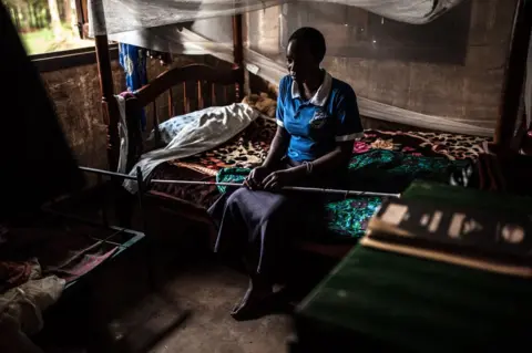 Aurelie Marrier d’Unienville/Sightsavers Sylvia sits on the edge of her bed.