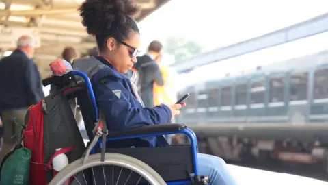 Getty Images/Peter Cade Disabled woman at train station (stock photo)