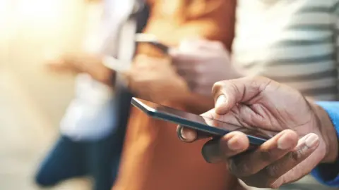 Getty Images Close up of someone using mobile phone