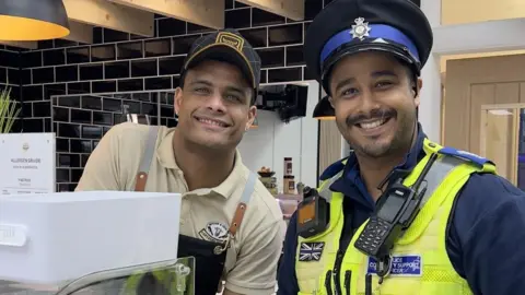 Cambridgeshire Constabulary PCSO with a member of staff in a Yaxley cafe
