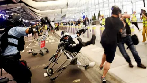 AFP A Hong Kong policeman (C) falls backwards as they scuffle with pro-democracy protesters