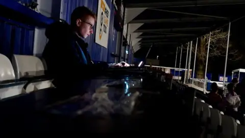 Jamie Niblock/BBC Jack in the press box, finalising a match report in an empty stand