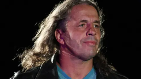 Getty Images Bret Hart acting as referee in the ring at a wrestling event in 2011