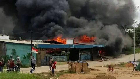 AFP A building, set on fire by rioting demonstrators, is seen in Sorong