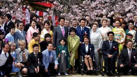 AFP Prime Minister Shinzo Abe (centre left) posing with entertainers and athletes during the cherry blossom viewing party hosted by the prime minister in 2017