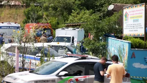 Reuters A view shows forensic technicians, ambulances and policemen outside a pre-school after a 25-year-old man attacked children, killing several and injuring others, according to local police and hospital, in Blumenau, in the southern Brazilian state of Santa Catarina, Brazil April 5, 2023.