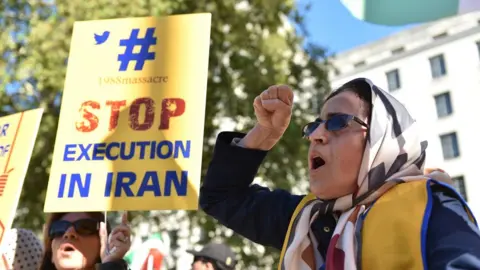 Getty Images People protest against the death penalty in Iran opposite Downing Street as a march to demand a people's vote against Brexit passes by on October 20, 2018 in London, UK