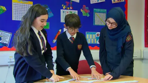 Three students at Kings Road Primary studying