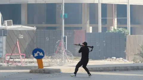 Reuters A militia fighters prepares to fire a rocket-propelled grenade in central Beirut (14 October 2021)