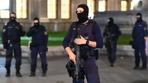 Getty Images Armed policemen stand guard in front of the state opera in Vienna