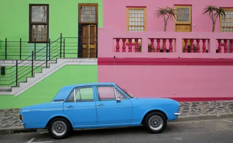 EPA A car is parked outside colored houses of the historic Bo Kaap area of Cape Town, South Africa, 15 March 2018. This former township, situated on the slopes of Signal Hill above the city center, is a historical centre of Cape Malay culture in the city and home to the first mosque in South Africa established in 1884 by immigrant workers. The area is one of the cities biggest tourist attractions.