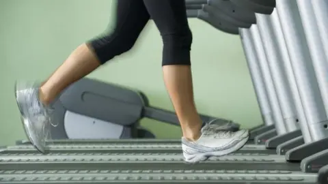 Science Photo Library Woman running on treadmill