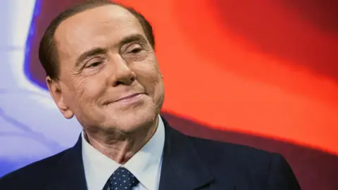 Berlusconi smiles at an event in 2018