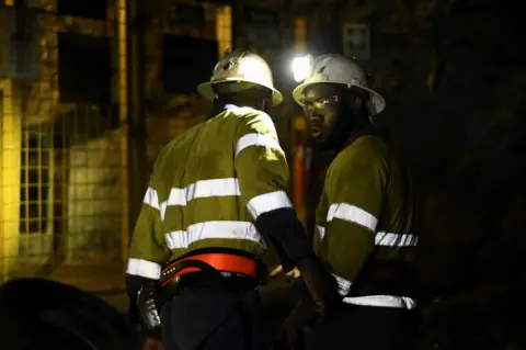 Reuters Men work during a rescue operation inside Perkoa mine where water is still being pumped out, four weeks after a flood trapped eight miners inside the galleries, in Perkoa, Burkina Faso on 13 May.