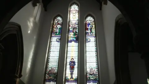 BBC The huge stained window at St Lawrence Church, in York