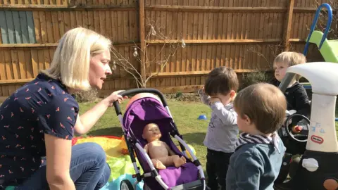 Sam Read/BBC Hana Foltynova, with three children, in her back garden
