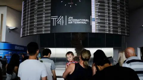 Getty Images People walk through international arrivals at terminal four at John F Kennedy (JFK) airport