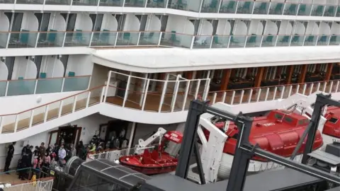 EPA Passengers disembark from the 151,000-tonne World Dream cruise liner docked at the Kai Tak Cruise Terminal in Hong Kong, China, 9 February 2020