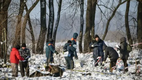 AFP Russian Emergency Ministry rescuers work at the site of a plane crash which occurred the day before in Ramensky district, on the outskirts of Moscow