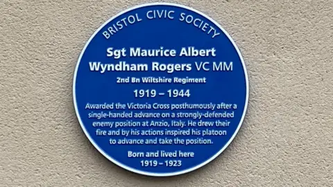 The blue plaque on the wall