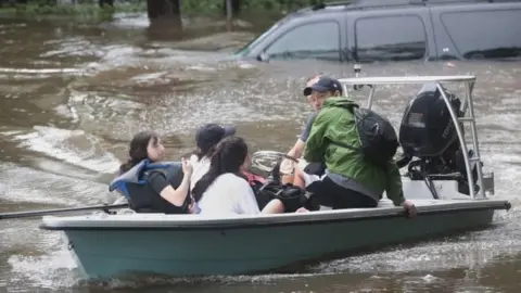 Getty Images Volunteers and officers from a Houston neighbourhood security patrol help rescue residents in River Oaks (27 August 2017)