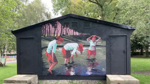 Gary James Mural of women footballers washing in the duck pond