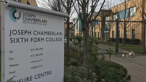 The college gates including a sign for the college