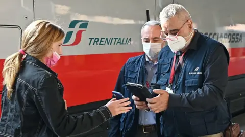 EPA Green Pass vaccine passports of passengers departing from the Porta Nuova railway station are checked by Italian State Railways personnel (Ferrovie dello Stato Italiane), in Turin