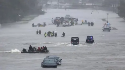 Reuters An image showing residents waiting to be rescued from the flood waters of Tropical Storm Harvey