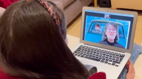 Grandmother Annette reads over a video call