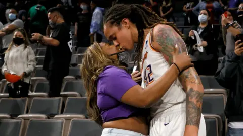 Getty Images Brittney Griner #42 of the Phoenix Mercury kisses her wife Cherelle Griner in the stands after the Mercury defeated the Las Vegas Aces