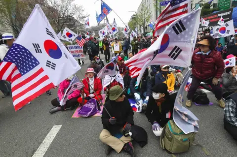 AFP Supporters of South Korea's former president Park Geun-hye gather during a rally demanding the release of Park Geun-hye outside the Seoul Central District Court in Seoul on 6 April 2018.