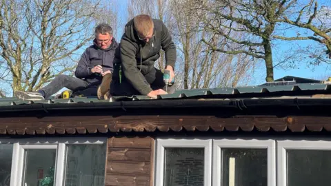 Two people who on a roof