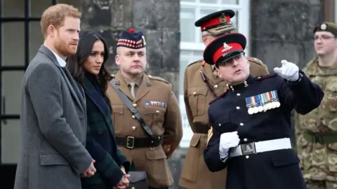 PA Prince Harry and Meghan Markle meet Sgt David Beveridge (right) before he fires the One o'clock gun at Edinburgh Castle