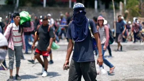 Reuters Central American migrants try to defend themselves with stones during an immigration raid