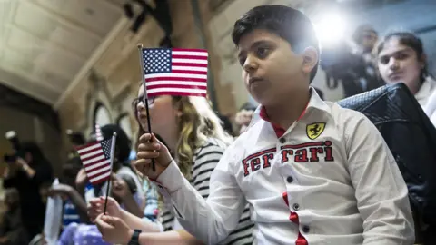 Getty Images Hoyannee Malatchanyan, a 10 year-old from Armenia, waves the American flag after taking the Oath of Allegiance to become a U.S. citizen during a citizenship ceremony at The Bronx Zoo, May 5, 2017